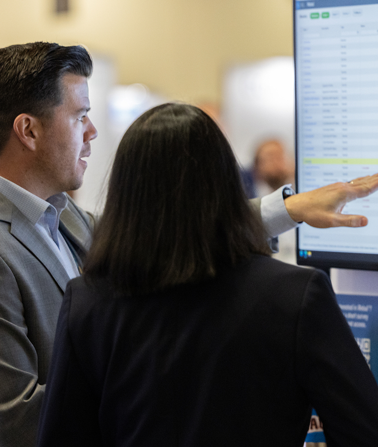 Two people looking at information on-screen.