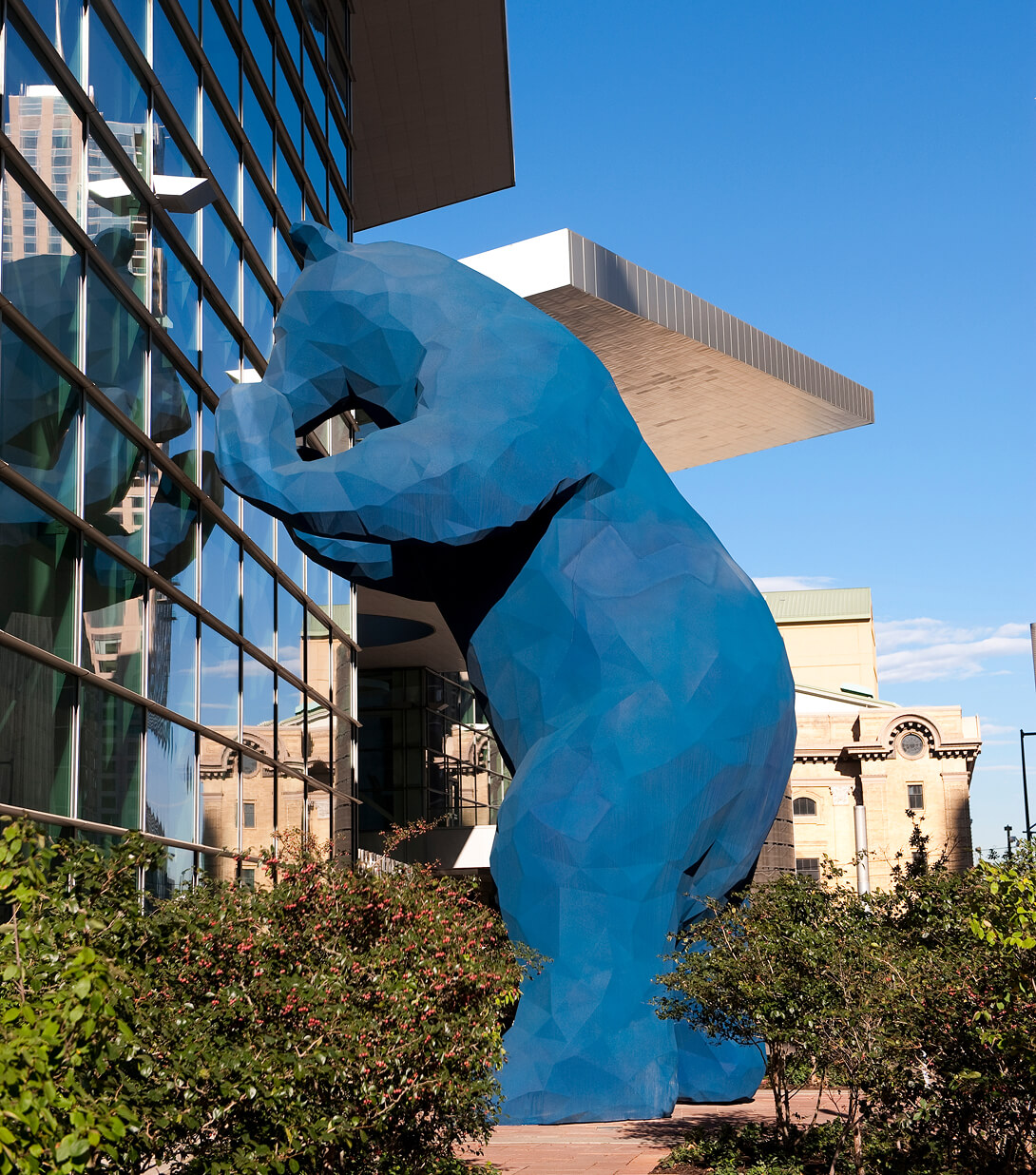 40-foot-high blue bear sculpture by Lawrence Argent peeking into the lobby of the Colorado Convention Center.