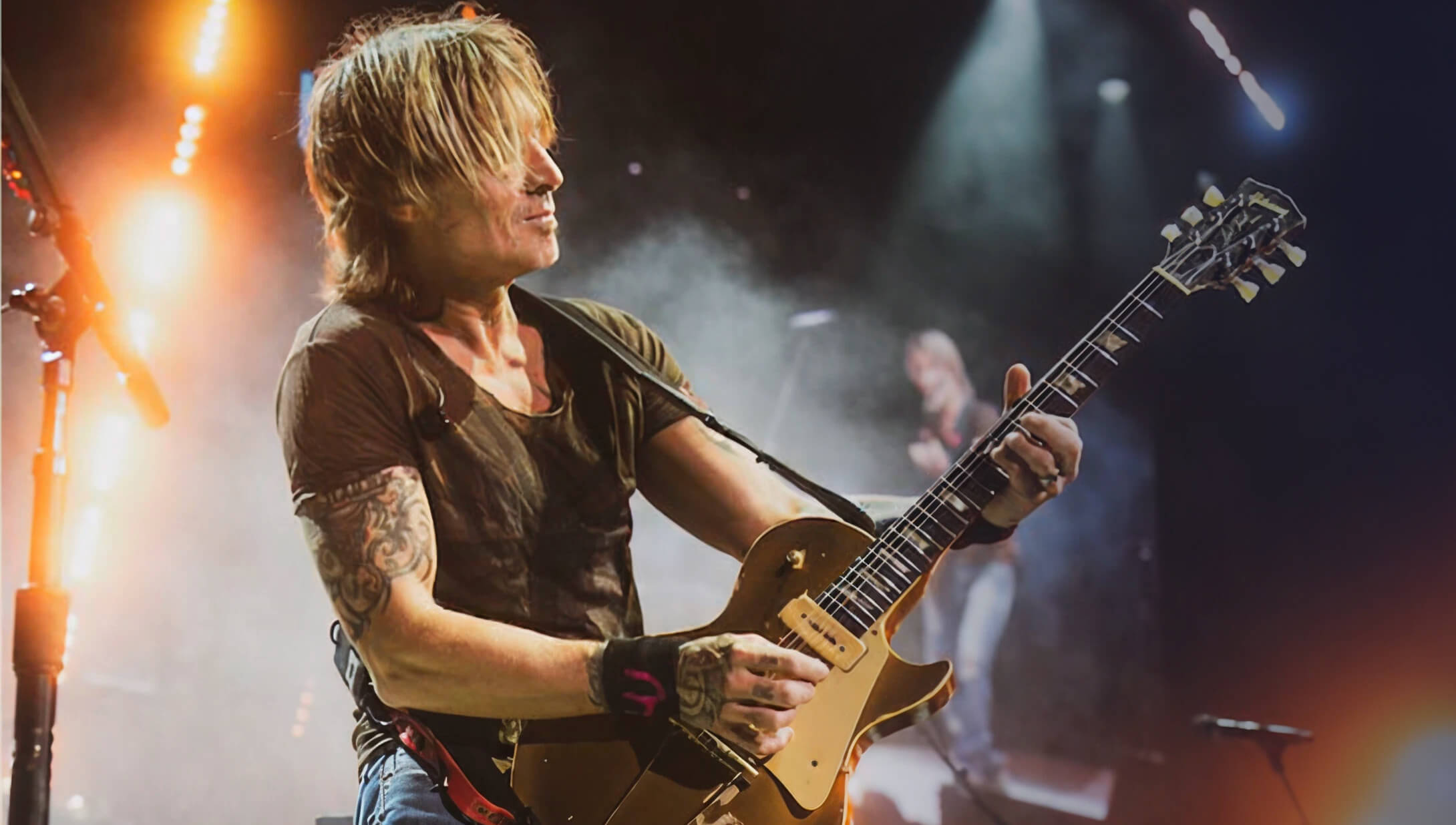 Keith Urban, Four-time Grammy Award winner and two-time CMA Entertainer of the Year, performing on stage.