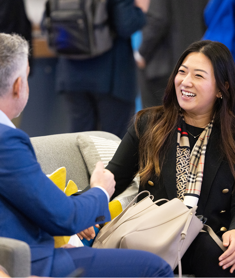 Two attendees conversing at IMPACT 2024.
