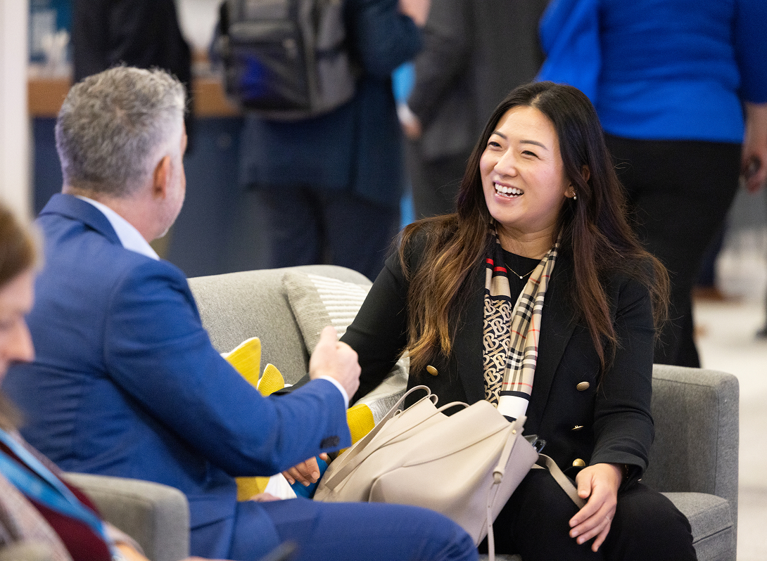 Two attendees conversing at IMPACT 2024.