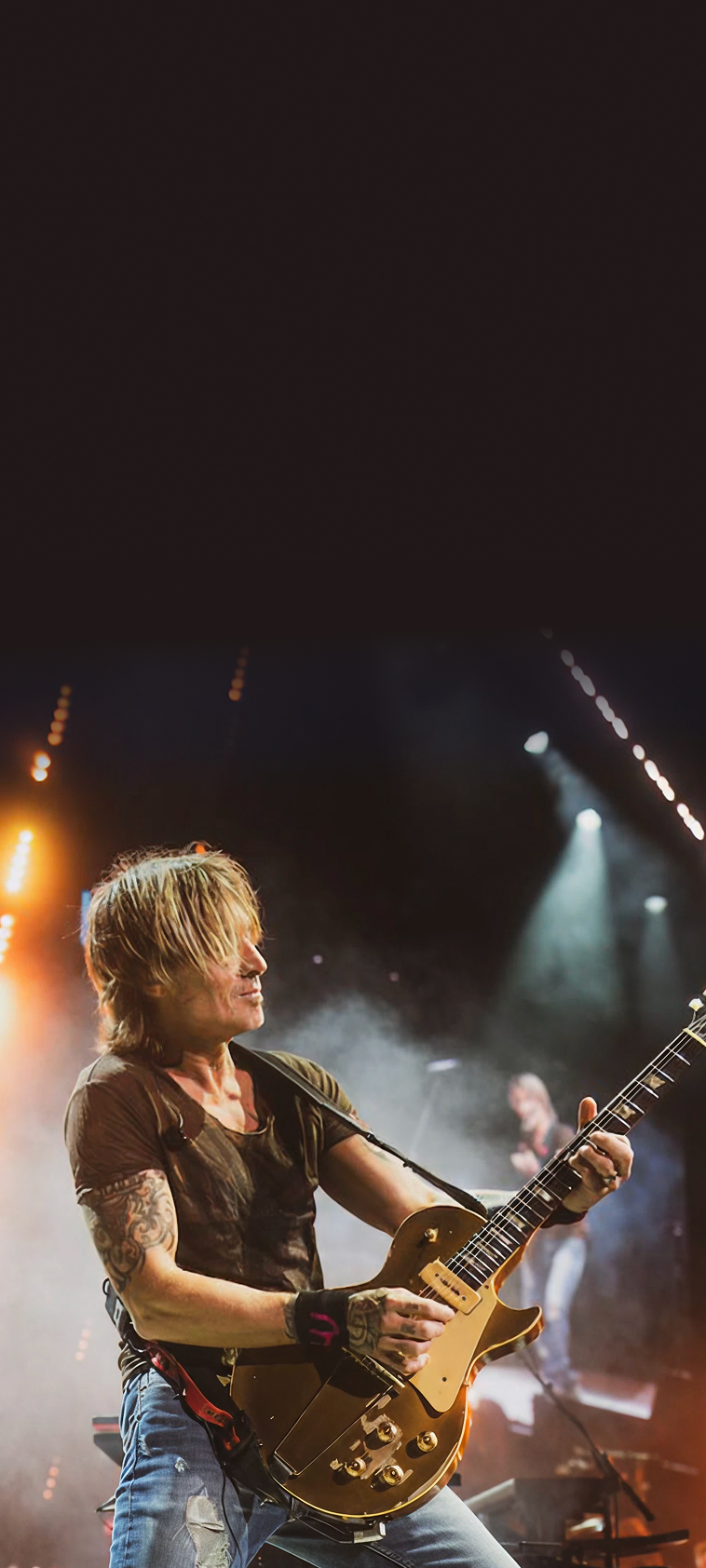 Keith Urban, Four-time Grammy Award winner and two-time CMA Entertainer of the Year, performing on stage.