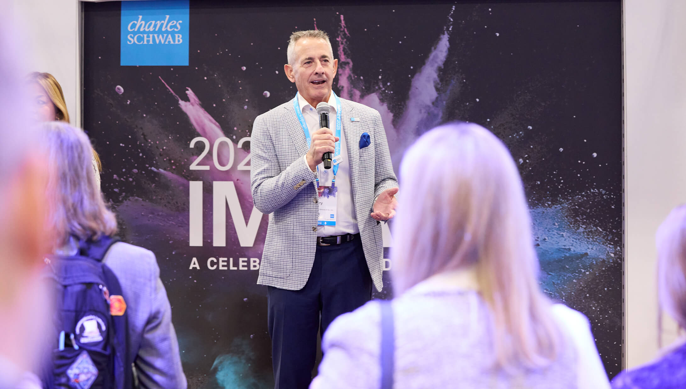 Man speaking to a standing audience at IMPACT 2025.