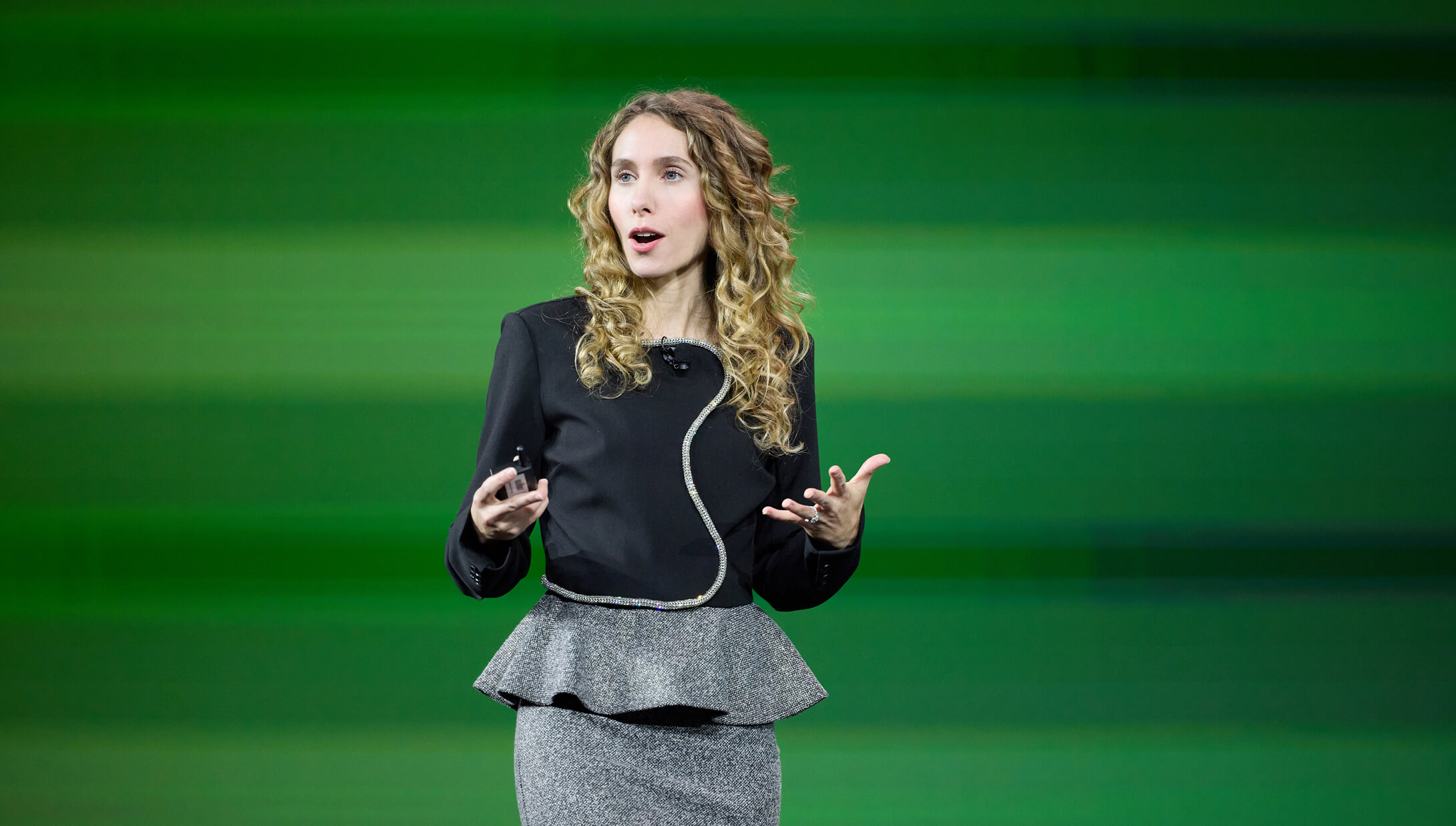 Kasley Killam, author of The Art and Science of Connection, speaking onstage in front of a green backdrop at IMPACT 2025.