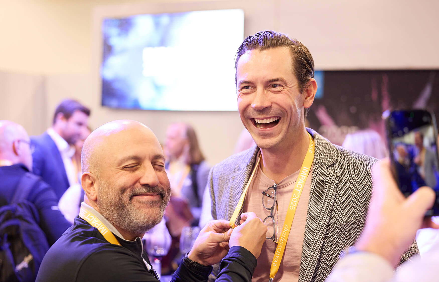Two attendees sharing a laugh at IMPACT 2025.
