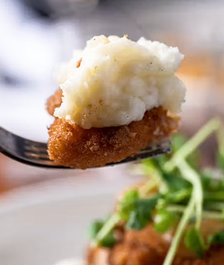Forkful of Ritz Cracker Crusted Chicken with whipped potatoes, onion butter, pepper jam, and chow chow, from Stillwater in Boston.